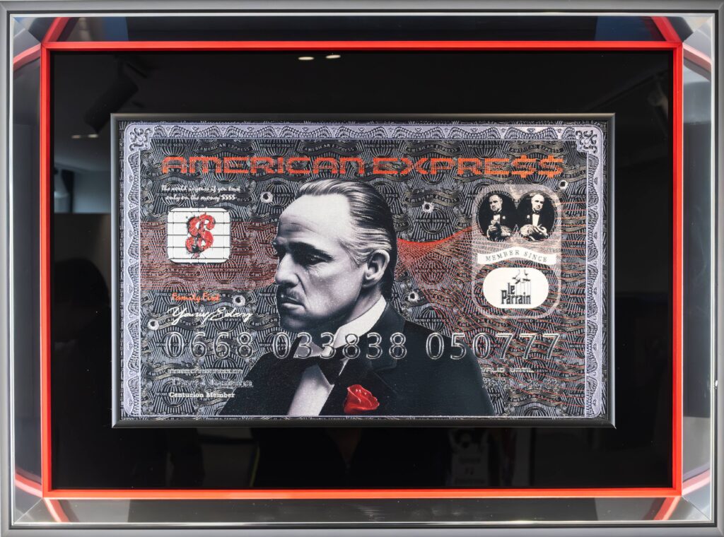 Yaniv Edery – Amex Dollar Bill De Niro Dit meesterlijke kunstwerk van Yaniv Edery combineert luxe, cinema en moderne pop-art. Centraal prijkt het iconische portret van Robert De Niro, vormgegeven op een American Express biljet. De combinatie van een legendarische acteur met een symbool van luxe en status maakt dit werk krachtig, verrassend en uniek. Het zwart-wit portret wordt versterkt door rode accenten, zoals de roos in de revers. Deze details brengen contrast en symboliek: passie, macht en elegantie. De textuur van het biljet, de subtiele patronen en de glanzende cijfers maken het geheel dynamisch en boeiend. Het is een kunstwerk dat direct indruk maakt en blijft fascineren. Edery speelt hier met thema’s van identiteit, macht en consumptie. De keuze voor De Niro, een icoon van film en karakter, versterkt de boodschap. Het werk laat zien hoe kunst, luxe en cultuur samen een nieuw verhaal vormen. Het is niet alleen een beeld, maar ook een statement over status en authenticiteit. Plaats Amex Dollar Bill De Niro in een woonkamer, galerie of kantoor en ervaar hoe het de ruimte onmiddellijk transformeert. Het straalt kracht, stijl en klasse uit. Dit werk is niet slechts decoratief, maar een icoon dat bewondering oproept. Dit meesterlijke kunstwerk van Yaniv Edery combineert luxe, cinema en moderne pop-art. Centraal prijkt het iconische portret van Robert De Niro, vormgegeven op een American Express biljet. De combinatie van een legendarische acteur met een symbool van luxe en status maakt dit werk krachtig, verrassend en uniek. Het zwart-wit portret wordt versterkt door rode accenten, zoals de roos in de revers. Deze details brengen contrast en symboliek: passie, macht en elegantie. De textuur van het biljet, de subtiele patronen en de glanzende cijfers maken het geheel dynamisch en boeiend. Het is een kunstwerk dat direct indruk maakt en blijft fascineren. Edery speelt hier met thema’s van identiteit, macht en consumptie. De keuze voor De Niro, een icoon van film en karakter, versterkt de boodschap. Het werk laat zien hoe kunst, luxe en cultuur samen een nieuw verhaal vormen. Het is niet alleen een beeld, maar ook een statement over status en authenticiteit. Plaats Amex Dollar Bill De Niro in een woonkamer, galerie of kantoor en ervaar hoe het de ruimte onmiddellijk transformeert. Het straalt kracht, stijl en klasse uit. Dit werk is niet slechts decoratief, maar een icoon dat bewondering oproept.