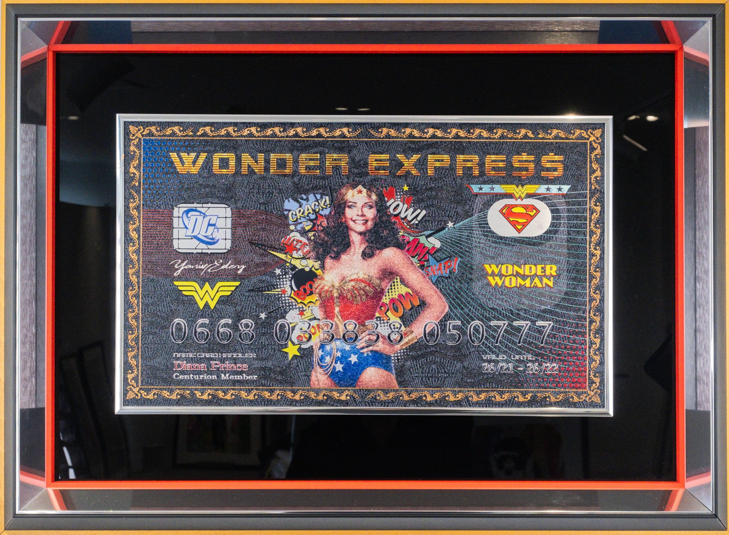 Yaniv Edery – Wonder Express Dit opvallende kunstwerk van Yaniv Edery brengt iconische popcultuur en luxe samen in één gedurfde compositie. Centraal staat Wonder Woman, afgebeeld met haar herkenbare uitstraling en kracht. Omringd door stripsymbolen en geplaatst op een biljet dat lijkt op een creditcard, ontstaat een unieke mix van superheldenenergie en consumptie-ironisering. De kleurrijke details en de glanzende afwerking geven het werk een dynamische uitstraling. Woorden als Pow! en Wow!voegen een speels stripgevoel toe, terwijl de compositie tegelijk elegant en krachtig blijft. Het contrast tussen de serieuze achtergrond en de vrolijke pop-art details maakt dit werk spannend en veelzijdig. Edery weet hier niet alleen een heldin te tonen, maar ook een boodschap. Wonder Woman wordt een symbool voor kracht, vrouwelijkheid en onafhankelijkheid. Tegelijkertijd zet de combinatie met een luxueuze creditcard aan tot nadenken over consumptie, status en moderne waarden. Het is kunst met lagen: speels, krachtig en betekenisvol. Het werk bruist van energie en trekt direct de aandacht. Elke penseelstreek en elk detail dragen bij aan een verhaal dat balanceert tussen fantasie en realiteit. Wonder Express is geen gewone decoratie, maar een krachtig statement dat emoties oproept en nieuwsgierigheid wekt.