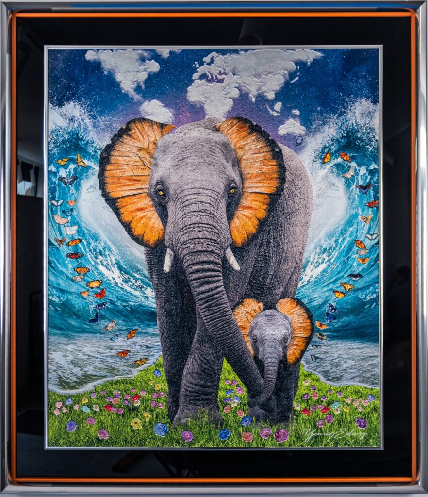 Yaniv Edery – Elephant Orange Dit indrukwekkende kunstwerk van Yaniv Edery toont twee majestueuze olifanten, een volwassen dier en een jong, die samen kracht en verbondenheid uitstralen. Hun oren, fel oranje gekleurd, contrasteren prachtig met het grijs van hun huid en geven het werk een unieke, energieke uitstraling. Op de achtergrond golft een machtige oceaan omhoog, vol dynamiek en kracht. Vlinders zweven door de lucht en voegen een vleugje lichtheid en speelsheid toe. Op de voorgrond bloeit een kleurrijk tapijt van bloemen, waardoor het geheel levendig en harmonieus aanvoelt. Het schilderij is een ode aan de natuur, waarin grootsheid en tederheid elkaar ontmoeten. De volwassen olifant straalt bescherming en wijsheid uit, terwijl het jong symbool staat voor groei, toekomst en kwetsbaarheid. Dit contrast maakt het werk gelaagd en emotioneel. De intense kleuren van de oren brengen warmte, terwijl de oceaan en lucht voor beweging en diepte zorgen. Zo ontstaat een krachtig samenspel van rust en energie. Edery weet met dit kunstwerk meer dan alleen een beeld neer te zetten. Hij vertelt een verhaal van balans tussen kracht en zachtheid, tussen aarde en water, tussen stilte en beweging. Elk detail, van de textuur van de huid tot de sprankeling van de golven, is zorgvuldig uitgewerkt en versterkt de betekenis van het werk. Elephant Orange is daarmee niet alleen visueel indrukwekkend, maar ook symbolisch rijk. Het werk laat zien hoe kunst emoties kan oproepen en tegelijkertijd een universele boodschap van harmonie en bescherming uitdraagt.