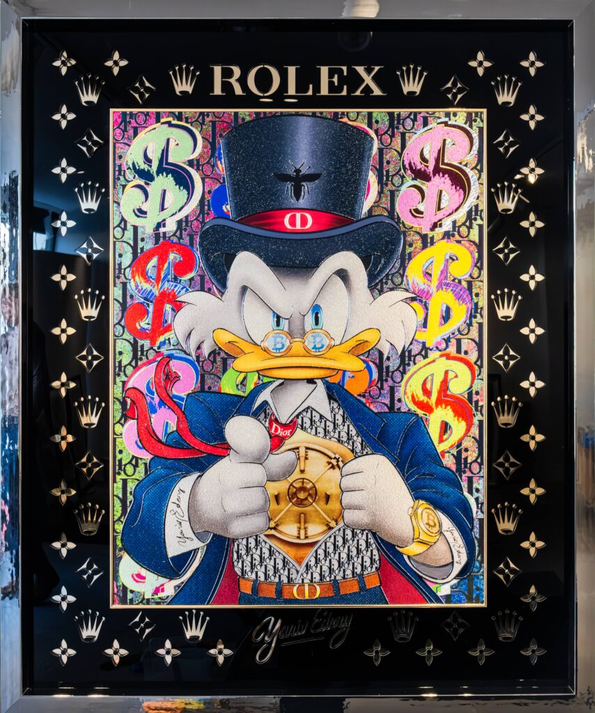 Yaniv Edery – Dagobert Vault Dit opvallende kunstwerk van Yaniv Edery toont Dagobert Duck zoals je hem nog nooit hebt gezien. Het iconische Disney-personage verschijnt hier in een luxueuze setting, gekleed in een stijlvol pak met hoge hoed en gouden details. Met een Rolex in zijn hand en een serieuze blik straalt hij macht, status en rijkdom uit. De achtergrond is gevuld met kleurrijke dollartekens en het herkenbare Rolex-logo. Deze combinatie van speelse pop-art en luxesymbolen zorgt voor een krachtig contrast. Het werk is zowel humoristisch als kritisch: het benadrukt onze fascinatie voor geld en status, maar doet dit met een knipoog. De levendige kleuren en scherpe details geven het werk dynamiek en energie. Dagobert Duck, symbool van rijkdom en hebzucht, wordt hier verheven tot een icoon van luxe en stijl. Het kunstwerk laat zien hoe popcultuur en consumptie hand in hand gaan en daagt de kijker uit om daarover na te denken. Edery weet met dit werk speelsheid te combineren met diepgang. De Rolex in de hand van Dagobert staat niet alleen voor luxe, maar ook voor tijd, macht en controle. Het gebruik van felle kleuren tegen de donkere achtergrond versterkt de intensiteit van de compositie. Dagobert Vault is daardoor niet slechts een vrolijk beeld, maar een krachtig statement. Het kunstwerk weet telkens opnieuw te verrassen. De mix van humor, luxe en ironie maakt het tot een uniek stuk dat direct opvalt en emoties oproept.