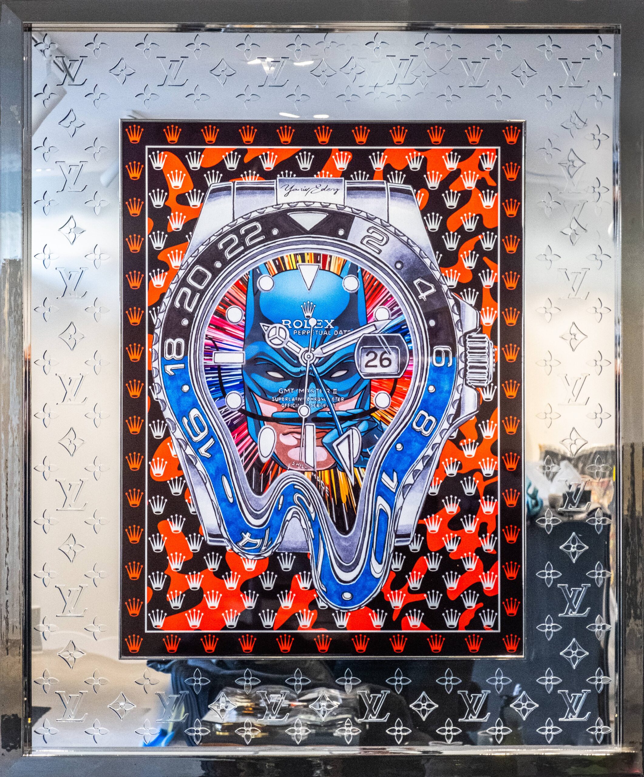 Rolex Batman Laser Cut – Yaniv Edery Rolex Batman Laser Cut is een explosie van luxe, kracht en symboliek. Het kunstwerk toont een vervormde Rolex GMT-Master, gecombineerd met iconische patronen van Louis Vuitton. Deze samensmelting van horlogerie en high fashion creëert een adembenemend visueel spektakel. Bovendien maakt de precisie van de laser cut het werk indrukwekkend modern. De felblauwe tinten contrasteren scherp met het vurige rood en zwart, waardoor de energie van het doek onmiddellijk voelbaar wordt. De Rolex in het midden lijkt te smelten, als een verwijzing naar tijd die vervormt. Dit versterkt de boodschap: luxe is niet alleen bezit, maar ook beleving. Het spel van symmetrie en chaos maakt het werk intrigerend. Elke blik onthult nieuwe details, elke lijn benadrukt vakmanschap. Daarom is Rolex Batman Laser Cut meer dan een kunstwerk; het is een statement over tijd, macht en identiteit. De reflecterende lijst, voorzien van het Louis Vuitton-patroon, verhoogt het gevoel van exclusiviteit. Het werk straalt verfijning uit, maar daagt ook uit. Want enerzijds toont het luxe, anderzijds breekt het deze traditie open door vervorming. Daardoor ontstaat een krachtige dialoog tussen traditie en vernieuwing. Dit meesterwerk is ideaal voor verzamelaars die durven kiezen. Het combineert modern design, iconische merken en artistieke vrijheid. Met krachtige kleuren, scherpe lijnen en opvallende details trekt het altijd aandacht.