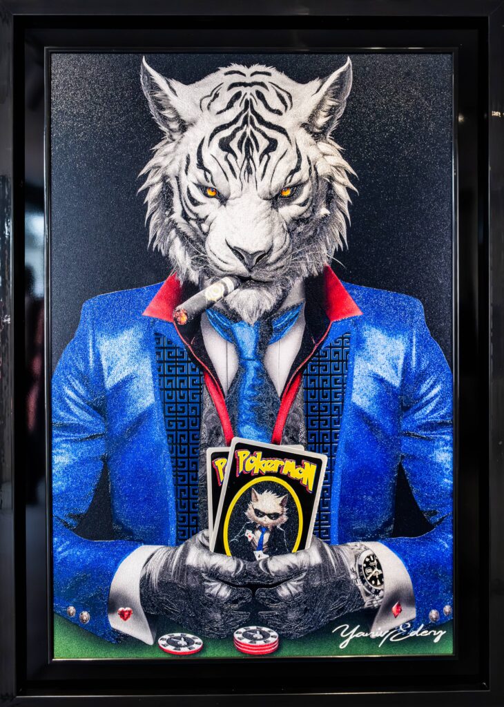 Yaniv Edery – Tiger Pok'Art Blue Suit Dit intrigerende kunstwerk van Yaniv Edery toont een trotse witte tijger, gekleed in een elegant blauw pak. Met een sigaar in de mond en kaarten in de hand straalt hij macht, lef en zelfvertrouwen uit. De intense gele ogen grijpen direct de aandacht en geven het werk een krachtige, bijna intimiderende uitstraling. De speelse twist zit in de kaarten die hij vasthoudt: opvallende Pokémon-kaarten. Dit onverwachte element doorbreekt de serieuze sfeer en zorgt voor humor en gelaagdheid. Het werk combineert luxe en elegantie met jeugdcultuur en speelsheid. Daardoor ontstaat een verrassend contrast dat de kijker blijft boeien. De compositie is sterk en zorgvuldig opgebouwd. Het glanzende blauwe pak, de rode accenten en de strakke details benadrukken stijl en klasse. Tegelijkertijd verwijzen de kaarten en de sigaar naar thema’s als macht, strategie en spel. Dit maakt het kunstwerk meer dan decoratief: het is een symbool van lef, luxe en ironie. Edery laat hier zijn talent zien voor het spelen met tegenstellingen. De kracht van de tijger, gecombineerd met de onverwachte speelsheid van popcultuur, maakt dit werk uniek. Het vertelt een verhaal over status, identiteit en de rol van symbolen in onze cultuur. Elk detail, van de textuur van de vacht tot de patronen in het kostuum, is uitgewerkt met precisie. Tiger Pok’Art Blue Suit is een statement piece dat energie en stijl uitstraalt en tegelijk een glimlach weet op te roepen.