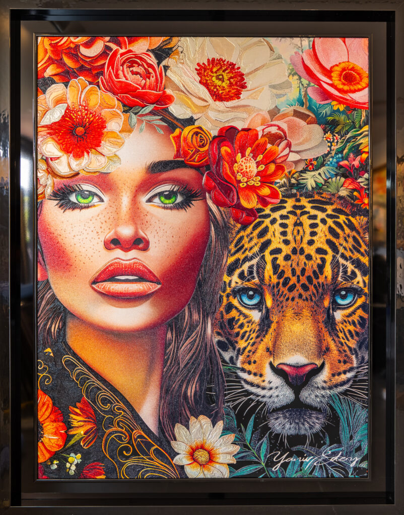 Yaniv Edery – Jaguar and Woman Green Eyes Dit indrukwekkende kunstwerk van Yaniv Edery brengt de mysterieuze schoonheid van een vrouw samen met de wilde kracht van een jaguar. De intense groene ogen van de vrouw trekken direct de aandacht, terwijl de doordringende blik van de jaguar een gevoel van macht en bescherming oproept. Samen vormen ze een krachtig duo dat elegantie en oerkracht verenigt. De omlijsting van kleurrijke bloemen versterkt de levendige sfeer van het werk. Rood, oranje en roze tinten brengen warmte en passie, terwijl het subtiele groen balans en frisheid toevoegt. Dit contrast tussen zachte vrouwelijkheid en ongetemde natuur maakt het kunstwerk meeslepend. Het nodigt de kijker uit om steeds opnieuw nieuwe details te ontdekken. Elke penseelstreek straalt energie uit. De precieze lijnen, de sprankelende kleuren en de expressieve gezichten zorgen voor een dynamisch geheel. Dit werk is niet enkel een schilderij, maar ook een symbool. Het vertelt een verhaal over harmonie tussen mens en natuur, over kracht, schoonheid en mysterie. Daardoor krijgt het een diepe betekenis die verder gaat dan decoratie. Plaats dit kunstwerk in een woonkamer, galerie of werkruimte en ervaar hoe het onmiddellijk de ruimte transformeert. De combinatie van vrouwelijke elegantie en dierlijke kracht geeft elke omgeving een unieke uitstraling. Het is een statement piece dat zowel bewondering als gesprek oproept.