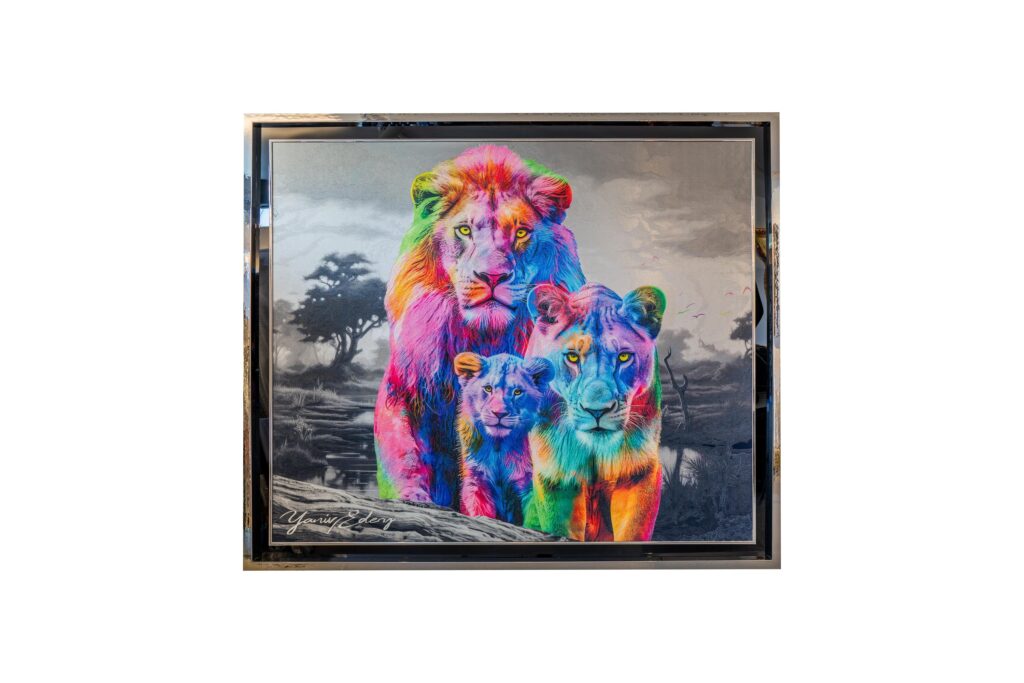 Yaniv Edery – Lion Family Multicolor Dit bijzondere kunstwerk van Yaniv Edery toont een trotse leeuwenfamilie in een explosie van kleuren. De leeuw, de leeuwin en hun welp staan samen afgebeeld, symbool voor kracht, bescherming en verbondenheid. De keuze voor felle regenboogkleuren geeft het werk een expressieve, moderne uitstraling die direct de aandacht trekt. De achtergrond is bewust in grijstinten gehouden. Dit contrast versterkt de intensiteit van de kleurrijke leeuwen en benadrukt hun aanwezigheid. Het maakt het werk krachtig en tijdloos tegelijk. Terwijl de savanne sober en stil oogt, straalt de familie warmte en vitaliteit uit. Edery legt niet alleen uiterlijke schoonheid vast, maar ook emotie en symboliek. De volwassen leeuwen vertegenwoordigen kracht en bescherming, terwijl het welpje staat voor onschuld, toekomst en hoop. Samen vertellen ze een verhaal over familiebanden, zorg en de kracht van samenhorigheid. De regenboogachtige kleuren brengen energie, diversiteit en positiviteit. Elk detail, van de manen van de leeuw tot de ogen van het welpje, is zorgvuldig uitgewerkt. Het gebruik van felle tinten maakt het werk dynamisch en speels, zonder afbreuk te doen aan de majestueuze uitstraling van de dieren. Lion Family Multicolor is daarmee meer dan een visueel spektakel. Het is een ode aan de natuur, een symbool van kracht en liefde, én een moderne interpretatie van de klassieke leeuwenfamilie. Het werk verrast telkens opnieuw en nodigt uit tot reflectie.