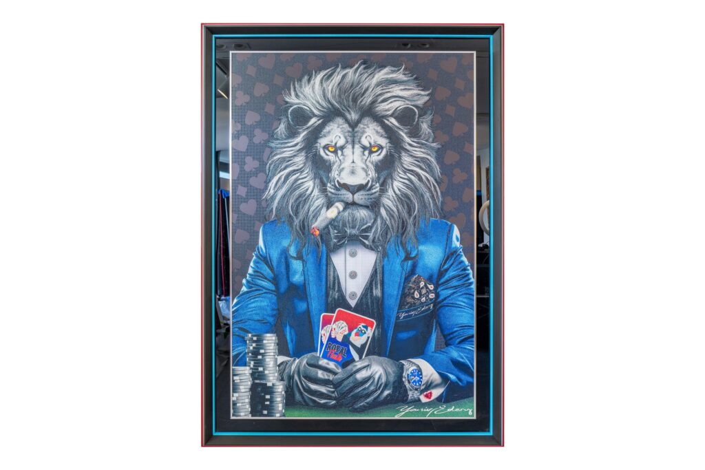 Yaniv Edery – Lion Poker Blue Dit indrukwekkende kunstwerk van Yaniv Edery toont een krachtige leeuw, gekleed in een stijlvol blauw pak. Met een sigaar in zijn bek en kaarten stevig in de hand straalt hij zelfvertrouwen, macht en strategie uit. De achtergrond vol subtiele patronen benadrukt de luxueuze sfeer, terwijl de intense blik van de leeuw direct de aandacht grijpt. Elk detail, van de sprankelende horloge tot de glans van het pak, draagt bij aan een meesterlijke balans tussen realisme en fantasie. Dit werk symboliseert meer dan alleen een spel. Het gaat om risico nemen, winnen en lef tonen. De combinatie van dierlijke kracht en menselijke elegantie maakt dit werk uniek. Het is niet alleen een decoratief kunstwerk, maar ook een krachtig statementstuk dat gesprekken uitlokt. Ideaal voor liefhebbers van moderne kunst, poker of wie graag een vleugje luxe toevoegt aan hun interieur. Het gebruik van levendige kleuren en scherpe contrasten maakt dat dit kunstwerk blijft fascineren. De blauwe tinten geven rust en diepte, terwijl het rood van de kaarten spanning toevoegt. Door de gedurfde stijl en sterke compositie krijgt elke ruimte een exclusieve uitstraling. Een perfecte keuze voor woonkamers, kantoren of luxe verzamelingen.