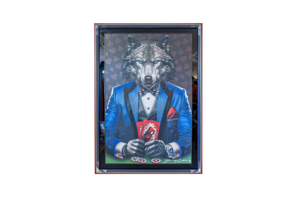 Yaniv Edery – Wolf Poker Blue Suit is een krachtig kunstwerk dat direct indruk maakt. De wolf, gehuld in een elegant blauw pak, straalt dominantie en strategie uit. Zijn scherpe blik en beheerste houding verraden ervaring, inzicht en onwrikbare vastberadenheid. Dit kunstwerk gaat niet alleen over poker, maar ook over macht, controle en stijl. De wolf zit strak in zijn blauwe pak, afgewerkt met subtiele rode accenten. Het contrast tussen het koele blauw en de vurige details benadrukt spanning en balans. Hij houdt zijn kaarten dicht bij zich, klaar om toe te slaan. Elke penseelstreek versterkt de intensiteit en de kracht van dit werk. De symboliek is duidelijk. De wolf staat voor instinct, intelligentie en leiderschap. In combinatie met poker, een spel van risico’s en strategie, ontstaat een fascinerende metafoor. Dit werk is een ode aan lef en berekening, aan elegantie en wildheid. Het blauwe pak staat symbool voor rust, loyaliteit en vertrouwen. Toch verraadt de blik van de wolf een andere kant: scherp, oplettend en altijd alert. Het is deze dubbele laag die het kunstwerk zijn unieke kracht geeft. Wolf Poker Blue Suit is meer dan decoratie. Het is een visuele ervaring die blijft intrigeren. Een meesterlijk spel tussen kunst, emotie en symboliek. Het is een statement dat elke ruimte verheft en direct de aandacht trekt.