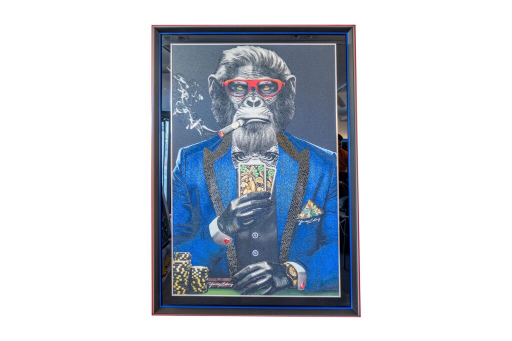 Monkey Poker Blue Suit – Yaniv Edery Monkey Poker Blue Suit van Yaniv Edery, straalt kracht en ironie uit. Een aap in een stijlvol blauw pak, rode bril en sigaar. Het beeld legt direct de nadruk op macht, status en spel. Iedere lijn is zorgvuldig geplaatst. Elk detail ademt humor, maar ook een scherpe kritiek op luxe en oppervlakkigheid. De kaarten in zijn hand symboliseren strategie, toeval en bluffen. Bovendien versterken de pokermunten en het horloge het thema van rijkdom. Het resultaat is een indrukwekkend kunstwerk dat elegantie combineert met satire. De kleuren zijn krachtig gekozen. Het blauwe pak straalt prestige uit. De rode bril trekt direct de aandacht. Daarnaast zorgt de rook van de sigaar voor een speelse dynamiek. Het contrast tussen dierlijk instinct en menselijke arrogantie is duidelijk voelbaar. Hierdoor ontstaat spanning én nieuwsgierigheid. Met Monkey Poker Blue Suit geeft Edery een visueel spel dat confronteert. Het is niet alleen een kunstwerk, maar ook een spiegel. Wie kijkt, ziet luxe en macht, maar ook een subtiele waarschuwing. Want achter elke façade schuilt een werkelijkheid van keuzes, risico’s en illusies. Dit maakt het werk universeel en tijdloos.
