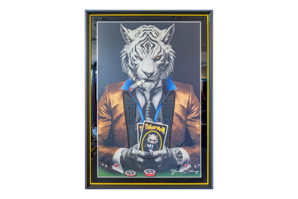 Yaniv Edery – Tiger Pok’Art Gold is een kunstwerk dat luxe, kracht en verfijning verenigt. De tijgerfiguur, elegant gekleed in een goudkleurig pak, straalt autoriteit en vastberadenheid uit. Zijn scherpe blik, stevige houding en de sigaar in zijn mond benadrukken de symboliek van macht en strategie. Met de pokerkaarten in de hand verbeeldt hij lef, spel en de kunst van keuzes maken. Het gebruik van goud is hierbij geen toeval. Het verwijst naar luxe, rijkdom en succes. Daardoor krijgt het werk niet alleen een decoratieve, maar ook een diepere betekenis. De intense contrasten en sterke lijnen zorgen voor dynamiek. Bovendien trekt de combinatie van dierlijke kracht en menselijke elegantie meteen de aandacht. Dit kunstwerk is meer dan een afbeelding, het is een krachtig statement. Plaats dit werk in een interieur en de ruimte verandert onmiddellijk. Het werk domineert, inspireert en nodigt uit tot gesprek. De tijger als symbool van moed en de pokerwereld als metafoor voor risico en strategie vormen samen een intrigerende dialoog. Het is kunst die blijft boeien en steeds opnieuw iets nieuws laat zien.