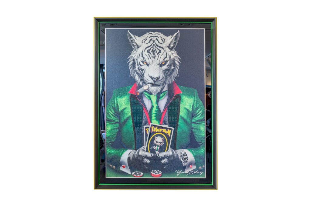 Yaniv Edery – Tiger Pok’Art Green is een krachtig en gedurfd kunstwerk dat onmiddellijk indruk maakt. De witte tijger, gekleed in een opvallend groen pak, straalt luxe, lef en strategie uit. Het dier, met zijn indringende blik en sigaar, is meer dan alleen een figuur: het is een symbool van dominantie en controle. In zijn handen houdt hij pokerkaarten, hét teken van risico, spel en overwinning. De groene kleur van het pak is veelzeggend. Groen staat voor balans, energie en vernieuwing. Het voegt een dynamische laag toe aan het werk en benadrukt de innerlijke kracht van de tijger. Door deze opvallende kleur wordt het kunstwerk niet alleen een blikvanger, maar ook een visuele metafoor voor groei en macht. Plaats dit werk in elke ruimte en de sfeer verandert direct. Het kunstwerk trekt de aandacht, prikkelt emoties en nodigt uit tot gesprek. Het is meer dan decoratie. Het is een verhaal van lef, strategie en elegantie. Elk detail, van de zorgvuldig geschilderde vacht tot de scherpe contouren van de kaarten, laat zien hoe nauwkeurig en stijlvol Yaniv Edery werkt.