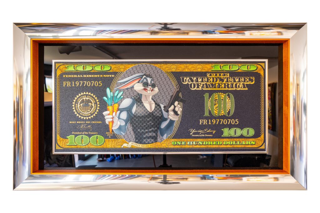 Yaniv Edery – Dollar Bill Bugs Bunny Het kunstwerk Dollar Bill Bugs Bunny van Yaniv Edery is een speelse en krachtige mix van humor, luxe en popcultuur. Op een gouden bankbiljet van honderd dollar verschijnt Bugs Bunny in een compleet nieuwe rol. Niet langer alleen de grappige tekenfilmheld, maar nu een stoer en zelfverzekerd icoon. Met een wortel in de ene hand en een wapen in de andere, daagt hij de toeschouwer direct uit. Edery gebruikt sterke contrasten en rijke details om spanning te creëren. Het klassieke dollarbiljet krijgt een moderne en brutale twist. De glanzende gouden achtergrond benadrukt rijkdom en macht, terwijl de karikaturale figuur van Bugs Bunny zorgt voor een verrassend contrast. Hierdoor ontstaat een werk dat zowel herkenbaar als vernieuwend is. De combinatie van stripfiguur en geldsymbool geeft een duidelijke boodschap. Humor, macht en luxe vloeien samen in een beeld dat ironie ademt. Bovendien versterkt de reliëf-techniek van Edery de beleving, waardoor de details tastbaar lijken en het kunstwerk extra diepte krijgt. Dollar Bill Bugs Bunny gaat verder dan een decoratief beeld. Het is een knipoog naar consumentisme, rijkdom en de kracht van populaire cultuur. Het werk is energiek, rebels en tegelijkertijd verfijnd. De artistieke spanning tussen cartoon en luxemunt maakt dit kunstwerk uniek en onderscheidend. Dit kunstwerk trekt direct de aandacht en laat een blijvende indruk achter. Het is een creatieve botsing tussen fantasie en realiteit, uitgevoerd met de typische precisie en lef van Yaniv Edery.