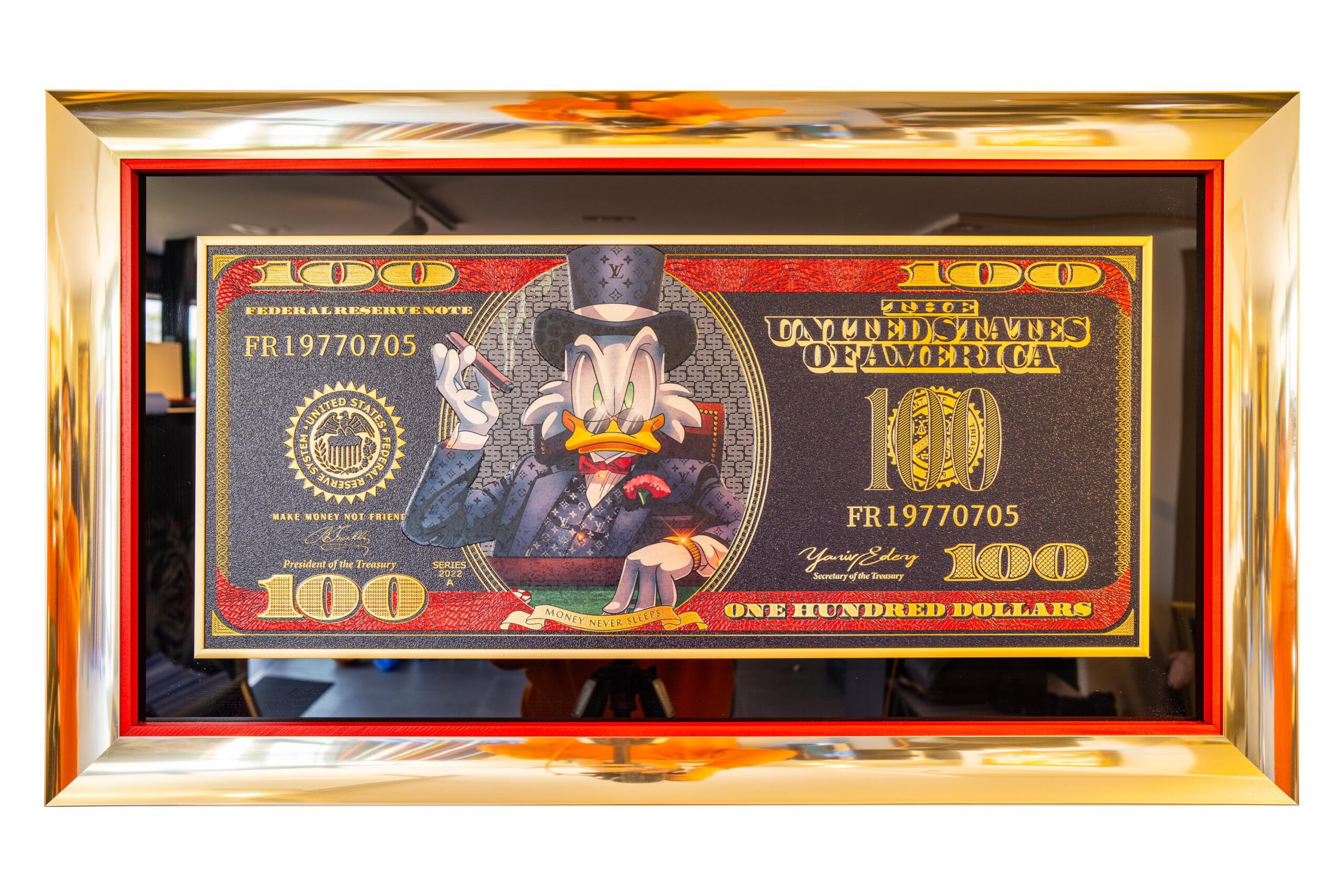 Dollar Bill Poker Dagobert (Copy) – Yaniv Edery Dollar Bill Poker Dagobert (Copy) van Yaniv Edery  straalt direct luxe en kracht uit. Yaniv Edery combineert iconische symbolen met moderne glamour. Het resultaat is een meesterwerk dat aandacht eist. Dagobert Duck, symbool van rijkdom, verschijnt stijlvol en uitdagend. Hij zit centraal op een dollarbiljet, getransformeerd tot een kunstzinnige boodschap. Elke lijn benadrukt macht. Bovendien versterken de gouden en rode tinten de dynamiek. Het werk is daardoor niet alleen een blikvanger, maar ook een gespreksonderwerp. Edery werkt met precisie. Hij gebruikt krachtige kleuren, scherpe contrasten en luxueuze details. Zo ontstaat er een spanningsveld tussen cartoon en realiteit. Dit maakt het kunstwerk provocerend én speels. De boodschap is helder: geld en macht zijn onlosmakelijk verbonden, maar altijd met een knipoog. Daarnaast valt de omlijsting op. Het gouden frame benadrukt de waarde en grandeur van het stuk. Het kunstwerk straalt daardoor nog meer exclusiviteit uit. De uitspraak “Money never sleeps” geeft extra betekenis. Het prikkelt de kijker en roept vragen op over status en overvloed.