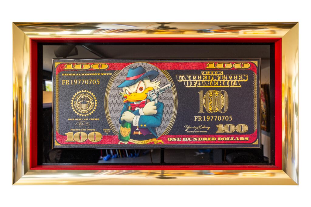 Yaniv Edery – Dollar Bill Dagobert Gun Het kunstwerk Dollar Bill Dagobert Gun van Yaniv Edery toont een iconisch beeld vol luxe en ironie. Dagobert Duck, symbool van rijkdom, verschijnt hier in een nieuwe rol. Hij draagt een chique outfit en houdt een pistool vast, waarmee hij kracht en dominantie uitstraalt. De achtergrond van het honderd dollar biljet versterkt het thema van macht en geld. Het gebruik van rood, goud en blauw geeft het werk een luxueuze en opvallende uitstraling. Hierdoor ontstaat een sterk contrast tussen stripfiguur en serieuze symboliek. Edery speelt bewust met de spanning tussen speelsheid en ernst. Dagobert Duck wordt niet alleen een karikatuur van rijkdom, maar ook een symbool van controle en invloed. Het pistool in zijn hand benadrukt de rauwe kant van macht, terwijl de glimlach een speelse knipoog geeft. Het kunstwerk zit vol details die het oog blijven trekken. De gedurfde kleurencombinaties geven diepte en intensiteit. Daardoor ontstaat een uniek samenspel tussen popart en maatschappelijk commentaar. De compositie maakt dit werk zowel uitdagend als intrigerend. Het roept vragen op over de relatie tussen geld, macht en identiteit. Tegelijkertijd blijft het herkenbaar en toegankelijk dankzij het gebruik van een populaire stripheld. Dollar Bill Dagobert Gun laat zien hoe Edery iconische figuren heruitvindt en plaatst in een wereld van luxe en ironische contrasten. Het resultaat is een kunstwerk dat confronteert, verleidt en amuseert.