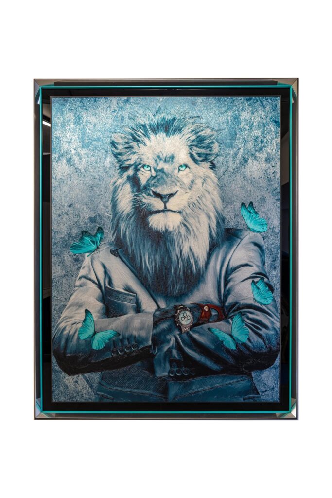 Yaniv Edery – Big Lion Blue Butterfly Het kunstwerk Big Lion Blue Butterfly van Yaniv Edery toont een krachtige leeuw, gekleed in een stijlvol pak, omringd door felblauwe vlinders. De intense blik van de leeuw straalt gezag, rust en zelfverzekerdheid uit. Daartegenover vormen de vlinders een zacht en speels contrast. Deze combinatie van kracht en lichtheid maakt het werk uniek en intrigerend. De koele blauwe tinten domineren het werk. Ze versterken de uitstraling van mysterie en elegantie. Bovendien geven de vlinders, die subtiel in reliëf lijken op te lichten, het geheel extra diepte. Dit contrast tussen de robuuste aanwezigheid van de leeuw en de fragiele schoonheid van de vlinders vertelt een verhaal over balans, harmonie en dualiteit. Edery weet met dit kunstwerk meer te doen dan enkel een beeld vast te leggen. Hij schept een dialoog tussen macht en kwetsbaarheid. Daardoor ontstaat een dynamiek die de toeschouwer blijft boeien. Het horloge aan de pols van de leeuw verwijst bovendien naar status, tijd en eeuwige kracht. Elk detail is zorgvuldig gekozen en versterkt het verhaal. De uitstraling van Big Lion Blue Butterfly is zowel modern als tijdloos. De combinatie van realisme, pop-art invloeden en opvallend reliëftechniek maakt dit werk tot een echte blikvanger. Het straalt luxe en verfijning uit, maar nodigt ook uit tot reflectie.