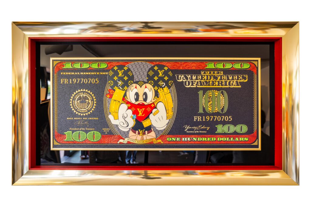 Yaniv Edery – Dollar Bill LV Mickey Mouse Dit opvallende kunstwerk van Yaniv Edery verenigt luxe, humor en moderne pop-art. Centraal op een iconisch honderd dollar biljet staat Mickey Mouse, gehuld in een opvallende Louis Vuitton outfit. Zijn vrolijke houding contrasteert met de luxe uitstraling van het biljet, waardoor een uniek spanningsveld ontstaat tussen speelsheid en status. De felle kleuren en gouden details trekken direct de aandacht. Het werk straalt energie uit en is tegelijk een subtiele knipoog naar consumptiecultuur en de waarde die we hechten aan iconen. De rode accenten geven warmte en kracht, terwijl de groene cijfers de herkenbare link met geld behouden. Dit maakt het kunstwerk niet alleen opvallend, maar ook betekenisvol. Edery speelt met symboliek. De keuze voor Mickey Mouse, wereldwijd symbool van plezier en jeugd, tegenover de luxueuze wereld van designermerken en geld, benadrukt contrasten in onze samenleving. Het kunstwerk vertelt meer dan een verhaal; het zet aan tot reflectie én zorgt voor een glimlach. Elk detail, van de textuur van de biljetprint tot de sprankelende kleuren van Mickey’s outfit, is met precisie uitgewerkt. Dollar Bill LV Mickey Mouse is daarmee niet zomaar een kunstwerk, maar een dynamisch statement. Plaats dit kunstwerk in een woonkamer, kantoor of galerie en ervaar hoe het direct energie, stijl en gesprek oproept. Het is perfect voor wie moderne kunst waardeert, maar ook houdt van speelsheid en luxe.