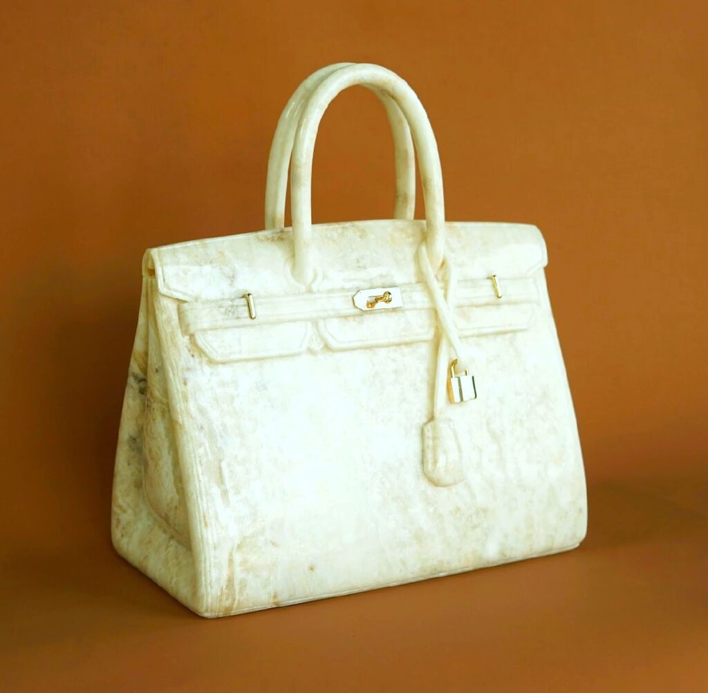 Birkin Marble – Een luxueuze sculptuur van de iconische Birkin-handtas, volledig vervaardigd uit hoogwaardig wit Carrara-marmer. Het stuk combineert de elegantie van haute couture met de tijdloze schoonheid van natuursteen, waardoor het een statement-object is voor kunst- en designliefhebbers.